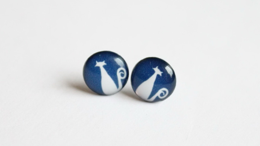 Cat stud earrings with navy blue background